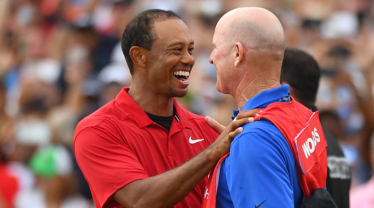 Tiger Woods shares a moment with caddie Joe LaCava after winning the 2018 Tour Championship.