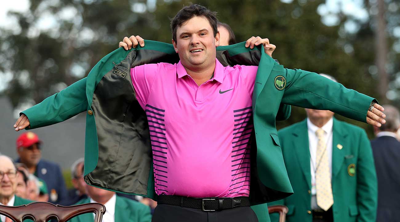 Patrick Reed slips on his Masters jacket at Augusta National.