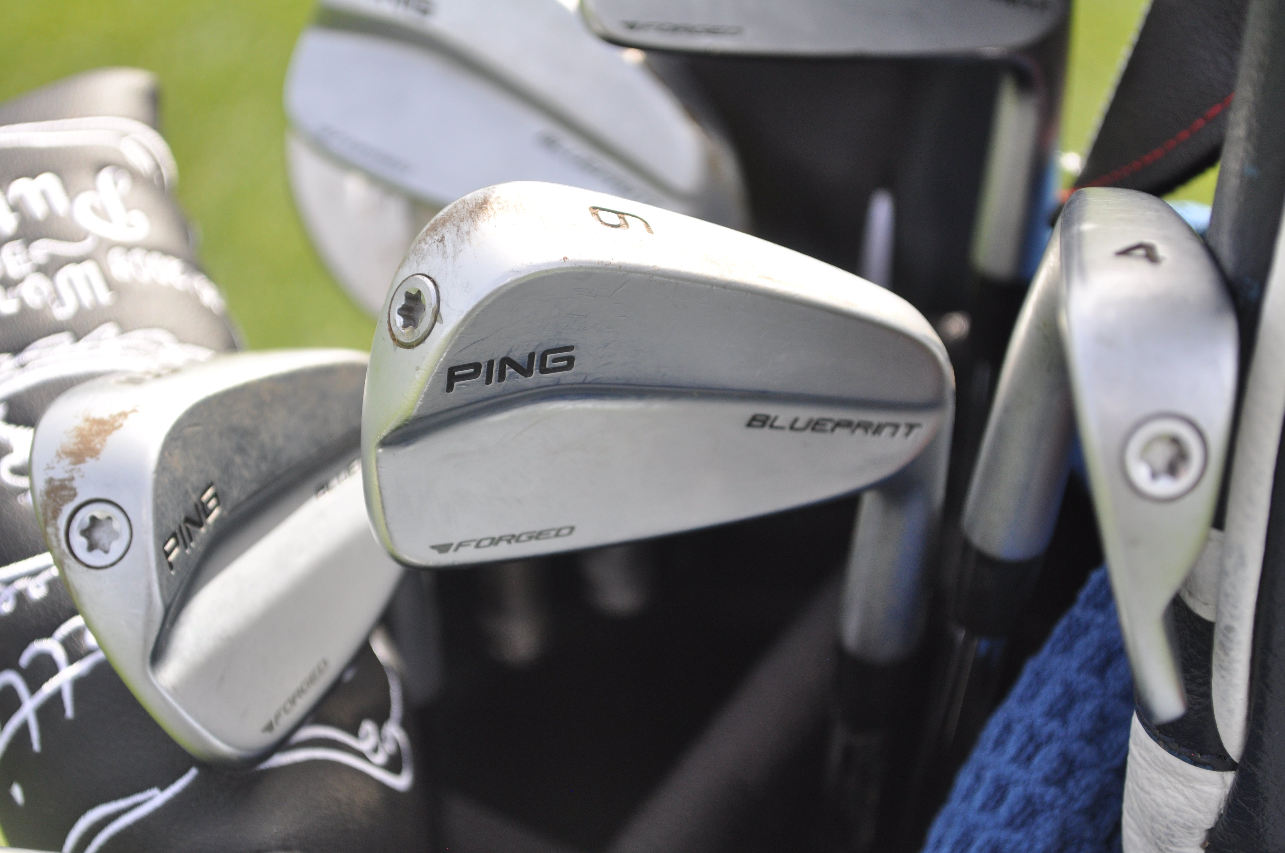 Tony Finau's Ping Blueprint irons have a solid layer of dirt from a recent range session. 