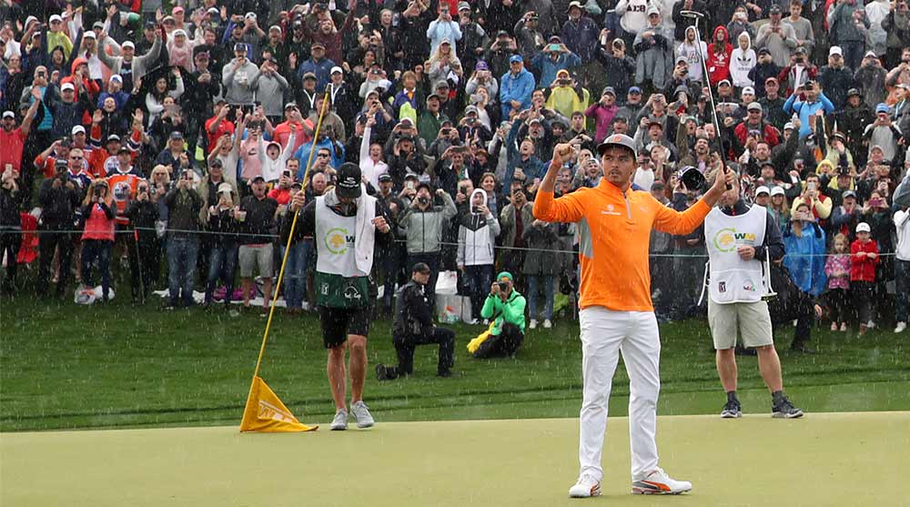 Rickie Fowler raises his arms after winning the Waste Management Phoenix Open.